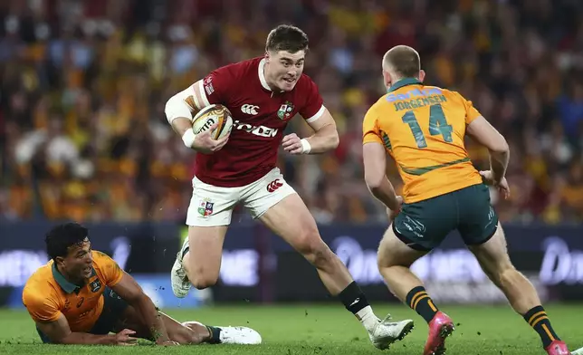 Tommy Freeman of the British &amp; Irish Lions, center, looks to go past Australia's Max Jorgensen during their first rugby union test in Brisbane, Australia, Saturday, July 19, 2025. (AP Photo/Pat Hoelscher)