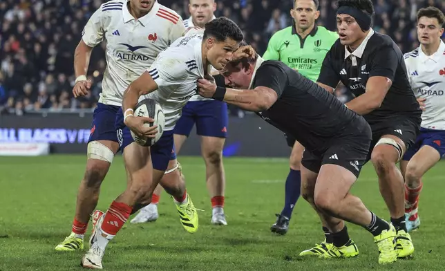 Tom Spring of France is tackled by New Zealand's Fletcher Newell during their rugby test against France in Dunedin, New Zealand, Saturday, July 5, 2025. (Marty Melville/Photosport via AP)
