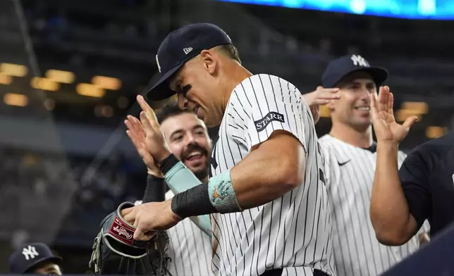 New York Yankees players celebrate with outfielder Aaron Judge, center, after the seventh inning of a baseball game against the Chicago Cubs, Friday, July 11, 2025, in New York. (AP Photo/Yuki Iwamura)