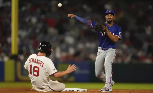 Los Angeles Angels' Nolan Schanuel, left, is forced out at seconds as Texas Rangers second baseman Marcus Semien fails to to throw out Taylor Ward at first during the sixth inning of a baseball game Tuesday, July 8, 2025 in Anaheim, Calif. (AP Photo/Mark J. Terrill)