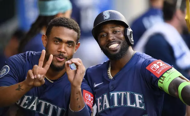 Seattle Mariners Randy Arozarena, right, poses with Seattle Mariners Julio Rodríguez after hitting a home run during the fourth inning of a baseball game against the Los Angeles Angels Saturday, July 26, 2025, in Anaheim, Calif. (AP Photo/William Liang)