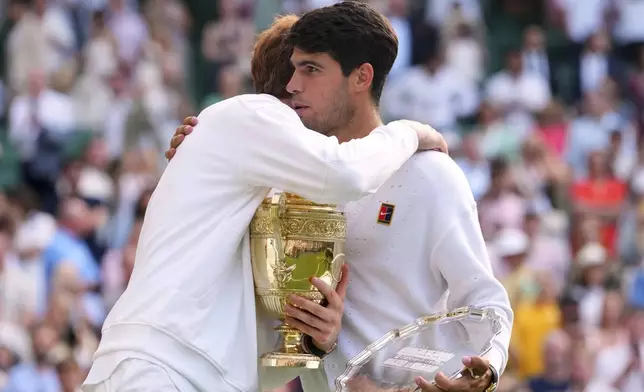 Jannik Sinner of Italy hugs Carlos Alcaraz of Spain after winning the men's singles final match at the Wimbledon Tennis Championships in London, Sunday, July 13, 2025.(AP Photo/Kirsty Wigglesworth)
