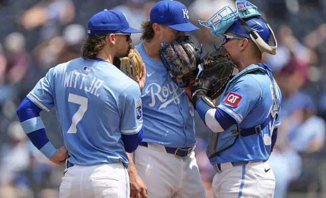 Kansas City Royals shortstop Bobby Witt Jr. (7), relief pitcher Hunter Harvey, center, and Freddy Fermin meet on the mound during the sixth inning of a baseball game against the Atlanta Braves Wednesday, July 30, 2025, in Kansas City, Mo. (AP Photo/Charlie Riedel)