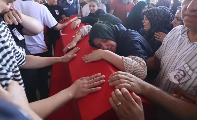 Relatives and friends mourn during the funeral of five rescue volunteers killed while battling a wildfire in northwestern Eskisehir province, in Ankara, Turkey, Thursday, July 24, 2025. (Yavuz Ozden/Dia Photo via AP)