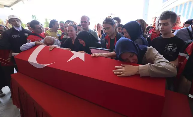 Relatives and friends mourn during the funeral of five rescue volunteers killed while battling a wildfire in northwestern Eskisehir province, in Ankara, Turkey, Thursday, July 24, 2025. (Yavuz Ozden/Dia Photo via AP)
