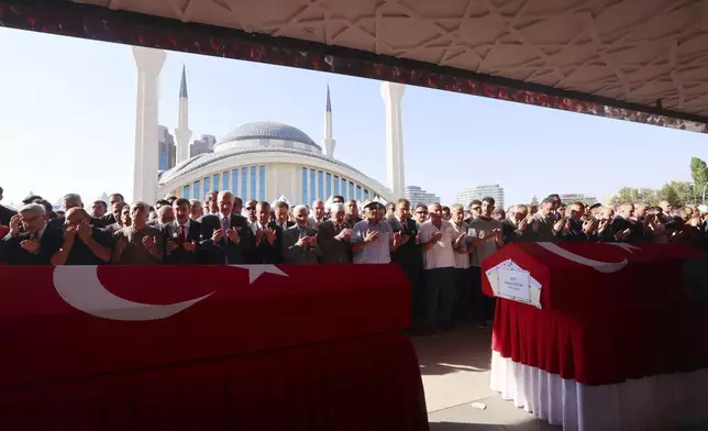 Relatives and friends pray during the funeral of five rescue volunteers killed while battling a wildfire in northwestern Eskisehir province, in Ankara, Turkey, Thursday, July 24, 2025. (Yavuz Ozden/Dia Photo via AP)