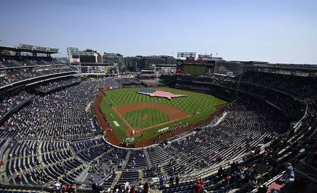 An American flag in the shape of the continental United States is displayed on the field before a baseball game between the Washington Nationals and the Boston Red Sox, Friday, July 4, 2025, in Washington. (AP Photo/Nick Wass)