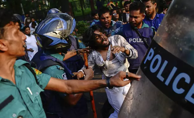 Policemen detain a student protesting near secretariat against the crash of a Bangladesh air force training jet into a school, demanding accountability, compensation for victims' families and the halt of training flights, in Dhaka, Bangladesh, Tuesday, July 22, 2025. (AP Photo/Mahmud Hossain Opu)