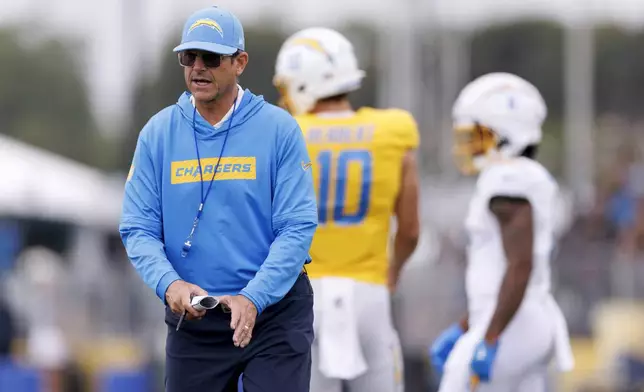 Los Angeles Chargers head coach Jim Harbaugh runs a drill during an NFL training camp Monday, July 28, 2025, in El Segundo, Calif. (AP Photo/Eric Thayer)