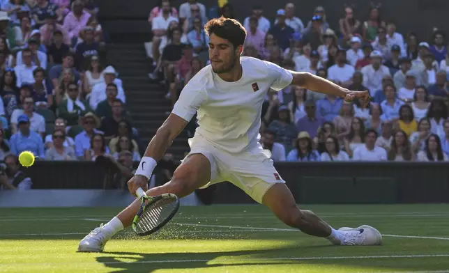 Spain's Carlos Alcaraz returns to Britain's Cameron Norrie during a quarterfinal men's singles match at the Wimbledon Tennis Championships in London, Tuesday, July 8, 2025. (AP Photo/Kirsty Wigglesworth)