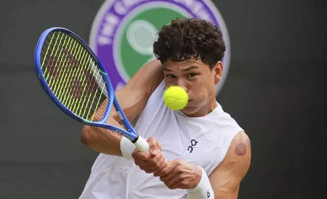 Ben Shelton of the U.S. plays a return to Jannik Sinner of Italy during the men's singles quarter final match at the Wimbledon Tennis Championships in London, Wednesday, July 9, 2025.(AP Photo/Kirsty Wigglesworth)