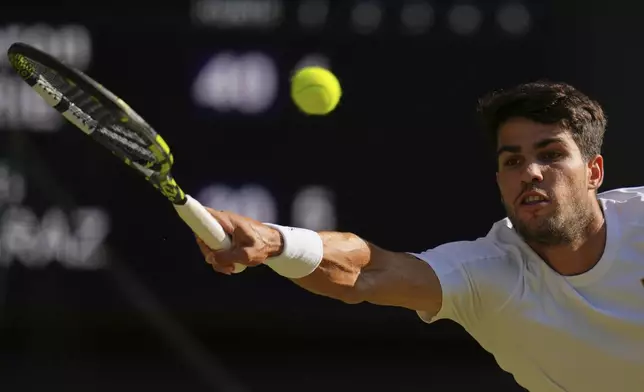 Spain's Carlos Alcaraz returns to Britain's Cameron Norrie during a quarterfinal men's singles match at the Wimbledon Tennis Championships in London, Tuesday, July 8, 2025. (AP Photo/Kirsty Wigglesworth)