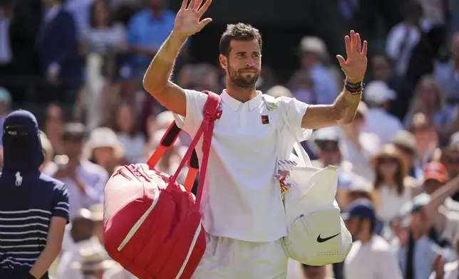 Karen Khachanov of Russia waves to the crowd after losing the men's singles quarter final match against Taylor Fritz of the U.S. at the Wimbledon Tennis Championships in London, Tuesday, July 8, 2025.(AP Photo/Kin Cheung)