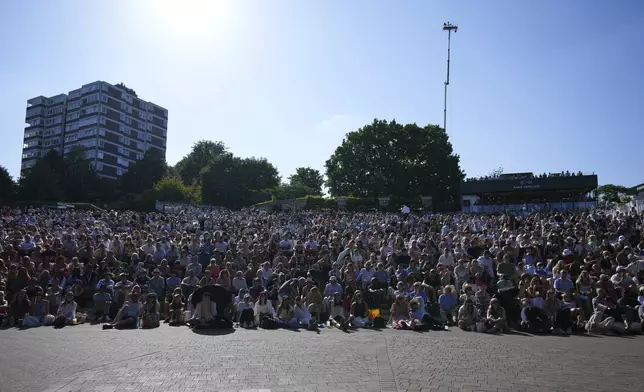 Spectators gather on 'The Hill' to watch on the screen Spain's Carlos Alcaraz play Britain's Cameron Norrie during a quarterfinal men's singles match at the Wimbledon Tennis Championships in London, Tuesday, July 8, 2025. (AP Photo/Joanna Chan)