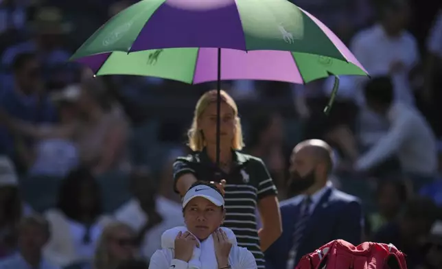 Amanda Anisimova of the U.S. rests under an umbrella during the women's singles quarter finals match against Anastasia Pavlyuchenkova of Russia at the Wimbledon Tennis Championships in London, Tuesday, July 8, 2025.(AP Photo/Kin Cheung)