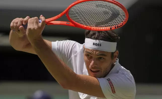 Taylor Fritz of the U.S. plays a return to Karen Khachanov of Russia during the men's singles quarter final match at the Wimbledon Tennis Championships in London, Tuesday, July 8, 2025.(AP Photo/Kin Cheung)