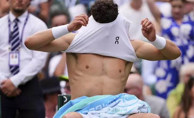 Ben Shelton of the U.S. changes his shirt during the men's singles quarter final match against Jannik Sinner of Italy at the Wimbledon Tennis Championships in London, Wednesday, July 9, 2025.(AP Photo/Kirsty Wigglesworth)