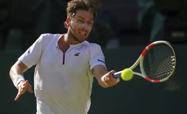 Britain's Cameron Norrie returns to Spain's Carlos Alcaraz during a quarterfinal men's singles match at the Wimbledon Tennis Championships in London, Tuesday, July 8, 2025. (AP Photo/Kirsty Wigglesworth)