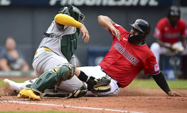 Athletics catcher Shea Langeliers tags out Cleveland Guardians outfielder Johnathan Rodríguez at home plate during the fourth inning of a baseball game, Sunday, July 20, 2025, in Cleveland. (AP Photo/David Dermer)