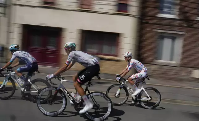 Slovenia's Tadej Pogacar wearing the best climber's dotted jersey, right, rides with Germany's Nils Politt, center, and France's Lenny Martinez during the third stage of the Tour de France cycling race over 178.3 kilometers (110.8 miles) with start in Valenciennes and finish in Dunkerque, France, Monday, July 7, 2025. (AP Photo/Mosa'ab Elshamy)