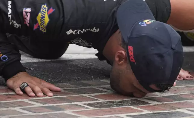 Bubba Wallace kisses the "Yard of Bricks" after winning a NASCAR Cup Series auto race at Indianapolis Motor Speedway, Sunday, July 27, 2025, in Indianapolis. (AP Photo/Darron Cummings)