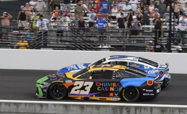 Bubba Wallace (23) leads Kyle Larson restart during a NASCAR Cup Series auto race at Indianapolis Motor Speedway, Sunday, July 27, 2025, in Indianapolis. (AP Photo/Darron Cummings)