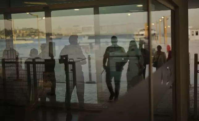Commuters wait as others arrive at the Kabatas ferry terminal on the European side of Istanbul, Turkey, Thursday, May 22, 2025. (AP Photo/Francisco Seco)