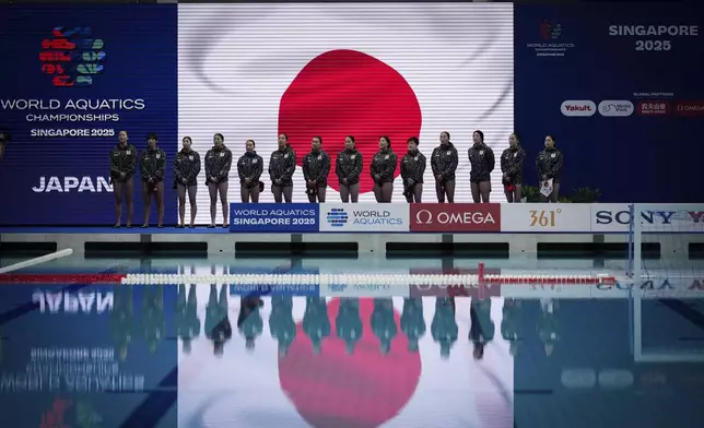 Japan's women water polo team stand during national anthem before the match against Greece at the women's water polo preliminary round at the World Aquatics Championships in Singapore, Tuesday, July 15, 2025. (AP Photo/Vincent Thian)