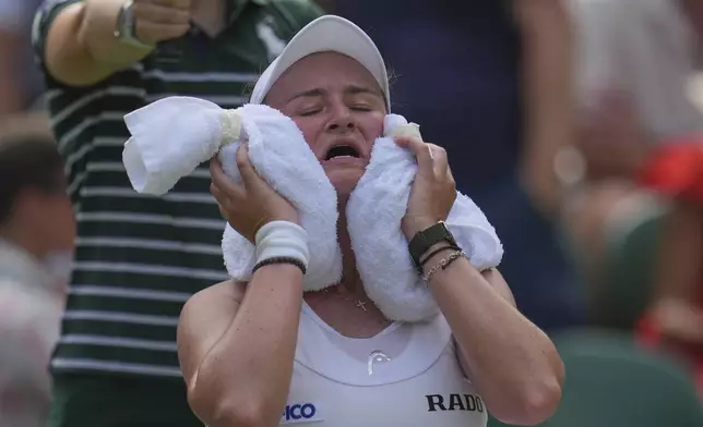 Barbora Krejcikova of Czech Republic tries to keep cool as she plays Alexandra Eala of the Philippines in their first round women's singles match at the Wimbledon Tennis Championships in London, Tuesday, July 1, 2025. (AP Photo/Kin Cheung)