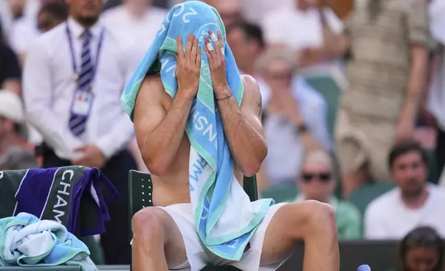Jack Draper of Britain dries himself with a towel during the first round men's single match against Sebastian Baez of Argentina at the Wimbledon Tennis Championships in London, Tuesday, July 1, 2025.(AP Photo/Kirsty Wigglesworth)