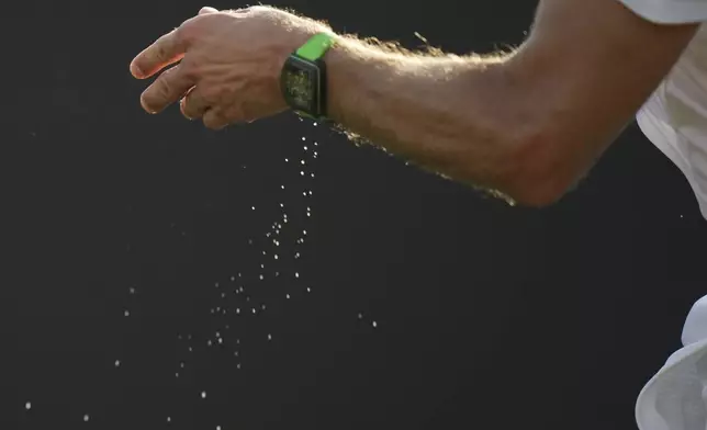 Sweat falls from the wrist of Grigor Dimitrov of Bulgaria as he prepares to serve to Yoshihito Nishioka of Japan during their first men's round singles match at the Wimbledon Tennis Championships in London, Tuesday, July 1, 2025. (AP Photo/Alastair Grant)