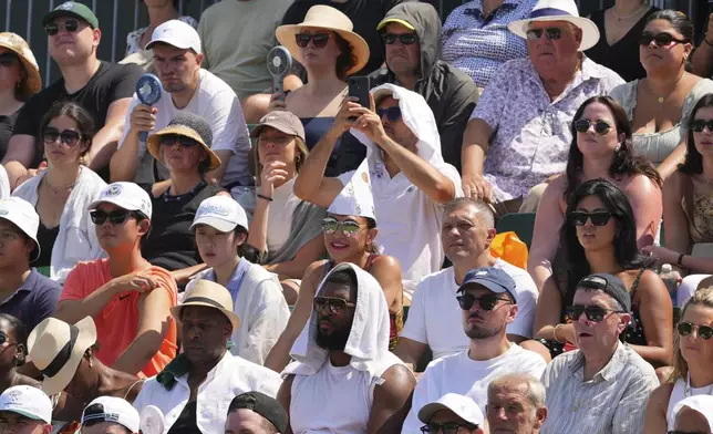 Spectators watch tennis at the Wimbledon Tennis Championships in London, Monday, June 30, 2025. (AP Photo/Kirsty Wigglesworth)