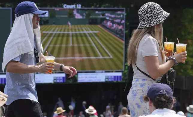 Spectaters watch tennis on huge screens on 'the Hill' during the Wimbledon Tennis Championships in London, Tuesday, July 1, 2025.(AP Photo/Kirsty Wigglesworth)