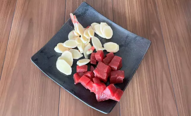 Bite size tuna chunks and sliced ginger, ingredients for a Japanese preserved food, called tsukudani, is displayed in the Tsukuda neighborhood of Tokyo on Monday, June 30, 2025. (AP Photo/Yuri Kageyama)