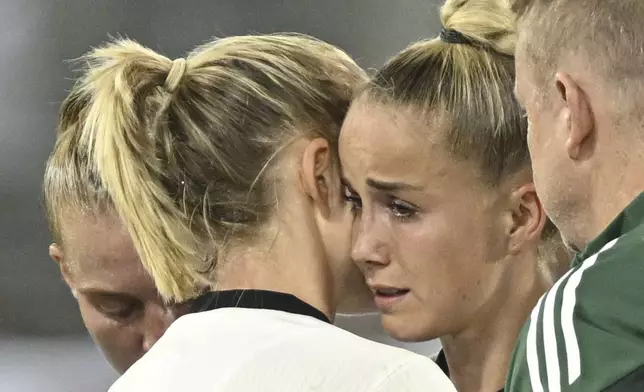Germany's Giulia Gwinn, center, reacts as she has to leave the pitch during the UEFA Women's EURO 2025 Group C soccer match between Germany and Poland at the Kybunpark stadium in St. Gallen, Switzerland, on Friday, July 4, 2025. (Gian Ehrenzeller/Keystone via AP)