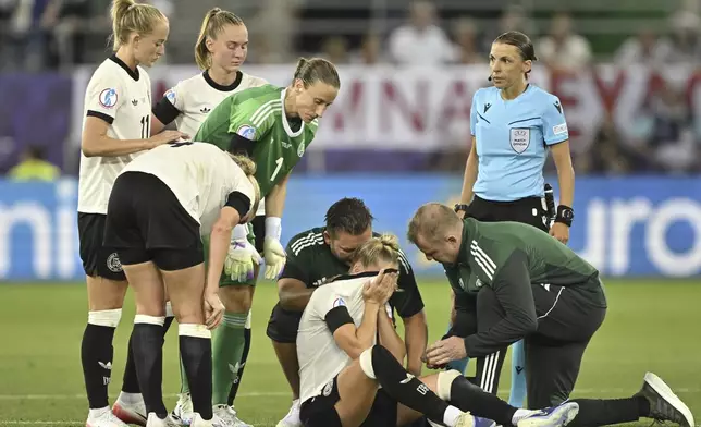 Germany's Giulia Gwinn, center, reacts as she has to leave the pitch during the UEFA Women's EURO 2025 Group C soccer match between Germany and Poland at the Kybunpark stadium in St. Gallen, Switzerland, on Friday, July 4, 2025. (Gian Ehrenzeller/Keystone via AP)