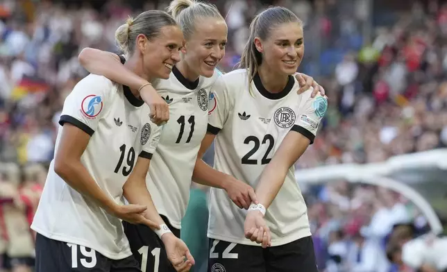 Germany's Lea Schueller, centre, celebrates with Klara Buehl, left, and Jule Brand after scoring her side's second goal during the Euro 2025, group C, soccer match between Germany and Denmark at St. Jakob-Park in Basel, Switzerland, Tuesday, July 8, 2025. (AP Photo/Martin Meissner)