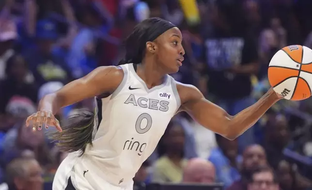 Las Vegas Aces guard Jackie Young takes control of the ball during the first half of a WNBA basketball game against the Dallas Wings in Arlington, Texas, Sunday, July 27, 2025. (AP Photo/LM Otero)