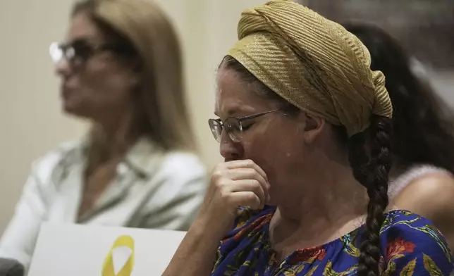 A woman reacts to testimony by freed hostage Ilana Gritzewsky at a ceremony presenting a report by the Dinah Project on sexual violence committed on Oct. 7, 2023 by Hamas, to Israel's first lady Michal Herzog, in Jerusalem, Tuesday, July 8, 2025. (AP Photo/Maya Alleruzzo)