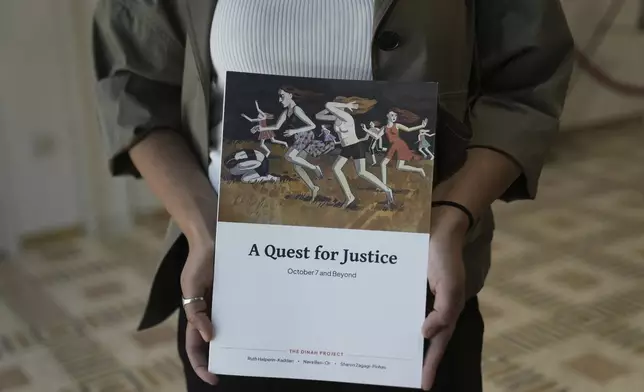 A copy of the report by the Dinah Project on sexual violence committed on Oct. 7, 2023 by Hamas is displayed by a journalist before a ceremony presenting the report to Israel's first lady Michal Herzog in Jerusalem, Tuesday, July 8, 2025. (AP Photo/Maya Alleruzzo)