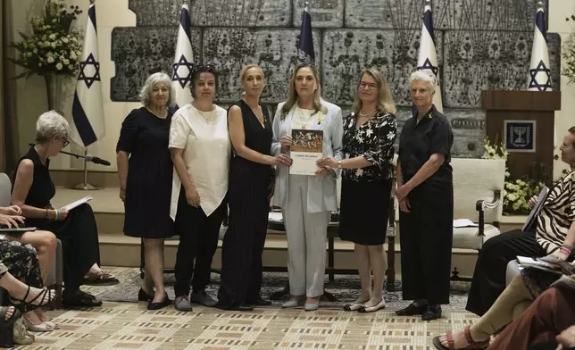 Israel's first lady Michal Herzog, center, is presented with a report by the Dinah Project on sexual violence committed on Oct. 7, 2023 by Hamas, in Jerusalem, Tuesday, July 8, 2025. (AP Photo/Maya Alleruzzo)