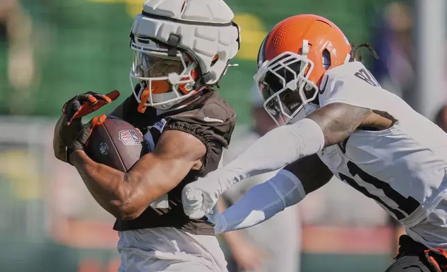 Cleveland Browns wide receiver Gage Larvadain, left, is pursued by cornerback Tony Brown II (11) during a practice at the team's NFL football training camp Wednesday, July 23, 2025, in Berea, Ohio. (AP Photo/Sue Ogrocki)