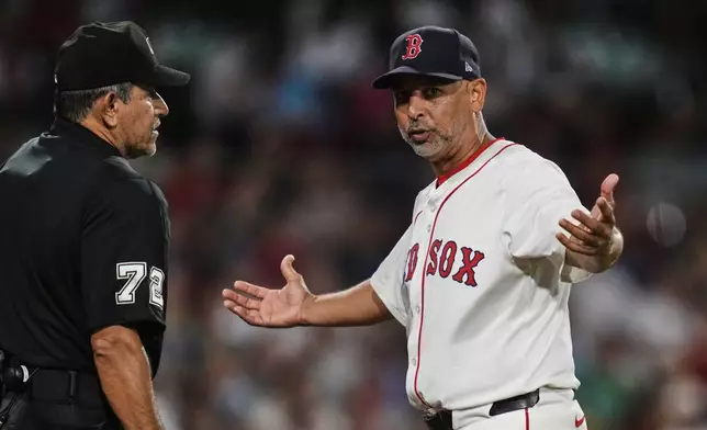 Boston Red Sox manager Alex Cora, right, argues a call with umpire Alfonso Marquez, left, during the sixth inning of a baseball game against the Colorado Rockies at Fenway Park, Monday, July 7, 2025, in Boston. (AP Photo/Charles Krupa)