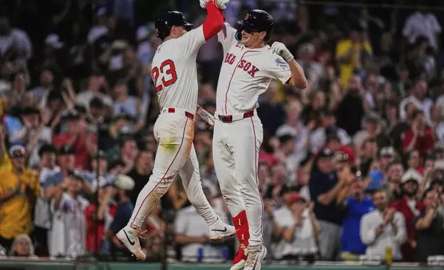 Boston Red Sox's Roman Anthony, right, celebrates with Romy Gonzalez (23) after his two-run home run against the Colorado Rockies during the fifth inning of a baseball game at Fenway Park, Monday, July 7, 2025, in Boston. (AP Photo/Charles Krupa)