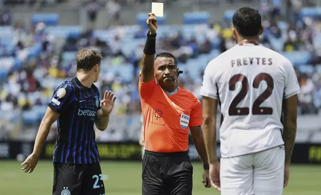 referee Ivan Arcides Barton Cisneros, of El Salvador, issues a yellow card to Fluminense's Juan Pablo Freytes (22) during the Club World Cup round of 16 soccer match between Inter Milan and Fluminense in Charlotte, N.C., Monday, June 30, 2025. (AP Photo/Nell Redmond)