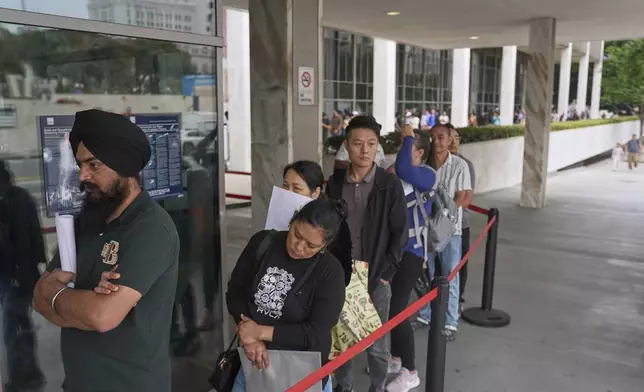 People line up outside the Los Angeles Federal Building in Los Angeles, housing the U.S. Immigration and Customs Enforcement (ICE) and U.S. Citizenship and Immigration Services (USCIS) on Wednesday, June 25, 2025. (AP Photo/Damian Dovarganes)