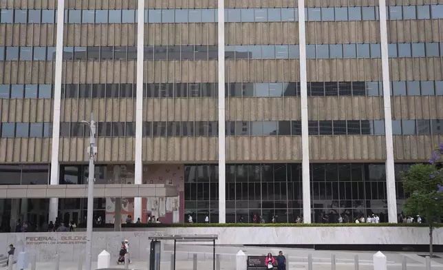 People line up outside the Los Angeles Federal Building in Los Angeles, housing the U.S. Immigration and Customs Enforcement (ICE) and U.S. Citizenship and Immigration Services (USCIS) on Wednesday, June 25, 2025. (AP Photo/Damian Dovarganes)