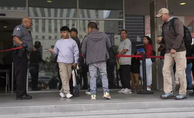 People line up outside the Los Angeles Federal Building in Los Angeles, housing the U.S. Immigration and Customs Enforcement (ICE) and U.S. Citizenship and Immigration Services (USCIS) on Wednesday, June 25, 2025. (AP Photo/Damian Dovarganes)