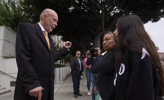Civil Rights Attorney Luis Carrillo, left, stands with clients, Margarita Flores, second from right, and her daughter, Estrella Rosas, far right, outside the ICE Los Angeles Staging Facility looking to find her daughter, Andrea Velez, a U.S. citizen who was detained by federal agents in an immigration raid downtown Los Angeles, on Wednesday, June 25, 2025. (AP Photo/Damian Dovarganes)