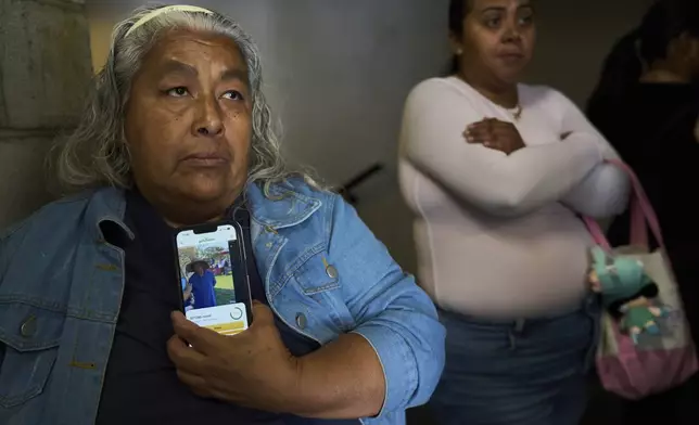 Anita Neri Lozano holds a picture of her detained husband, Ambrosio Enrique Lozano, an ice-cream vendor detained in Culver City, Calif., as she stands outside the ICE Los Angeles Staging Facility looking to visit him in Los Angeles, on Wednesday, June 25, 2025. (AP Photo/Damian Dovarganes)